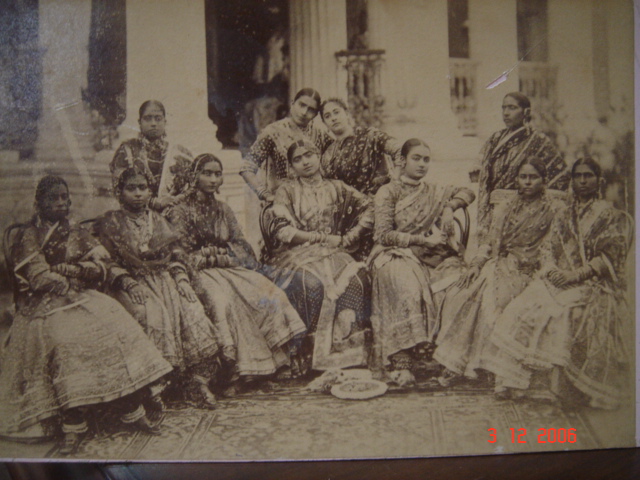 A postcard photograph of 11 dancing girls sitting together