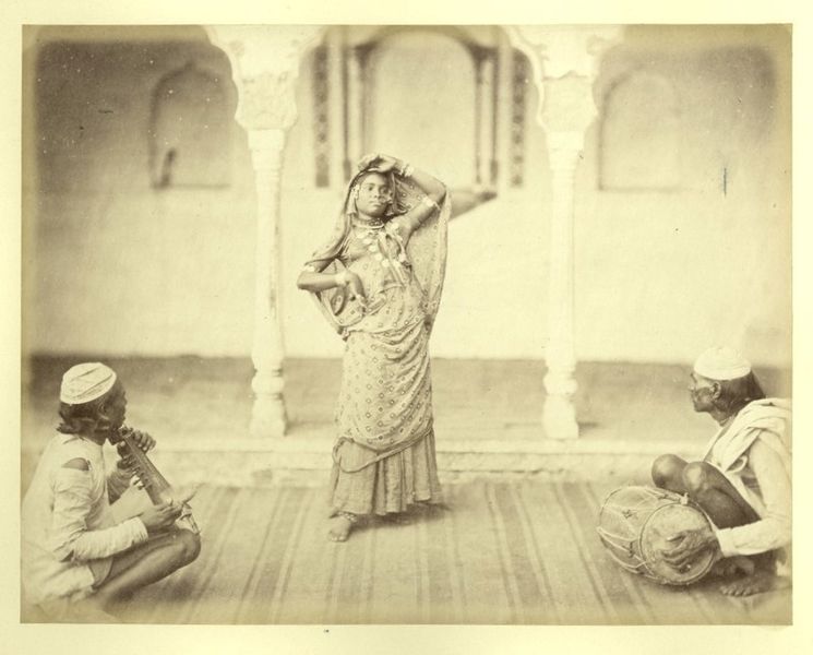 A photograph of a dancing girl and two musicians performing together