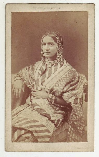 A studio photograph of a seated dancing girl