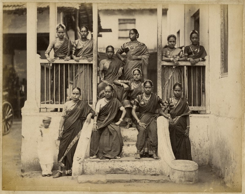 A photograph of nautch girls standing around a porch in Bombay
