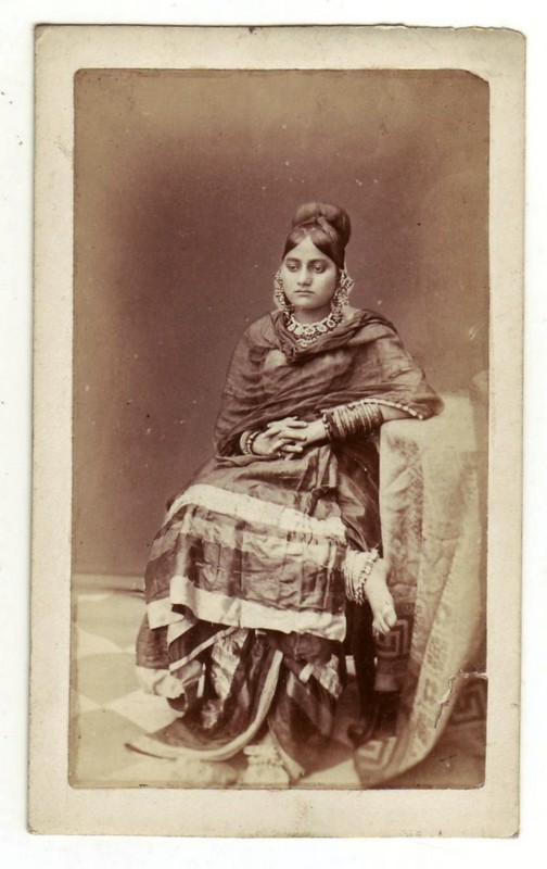 A posed photograph of a seated dancing girl in Lucknow 