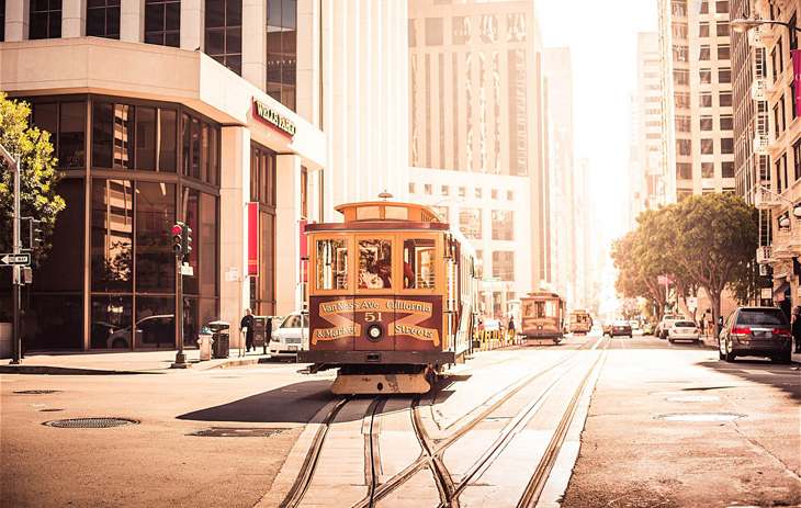 An image of a yellow streetcar driving by a building, representing CURL's Travel Bursaries.