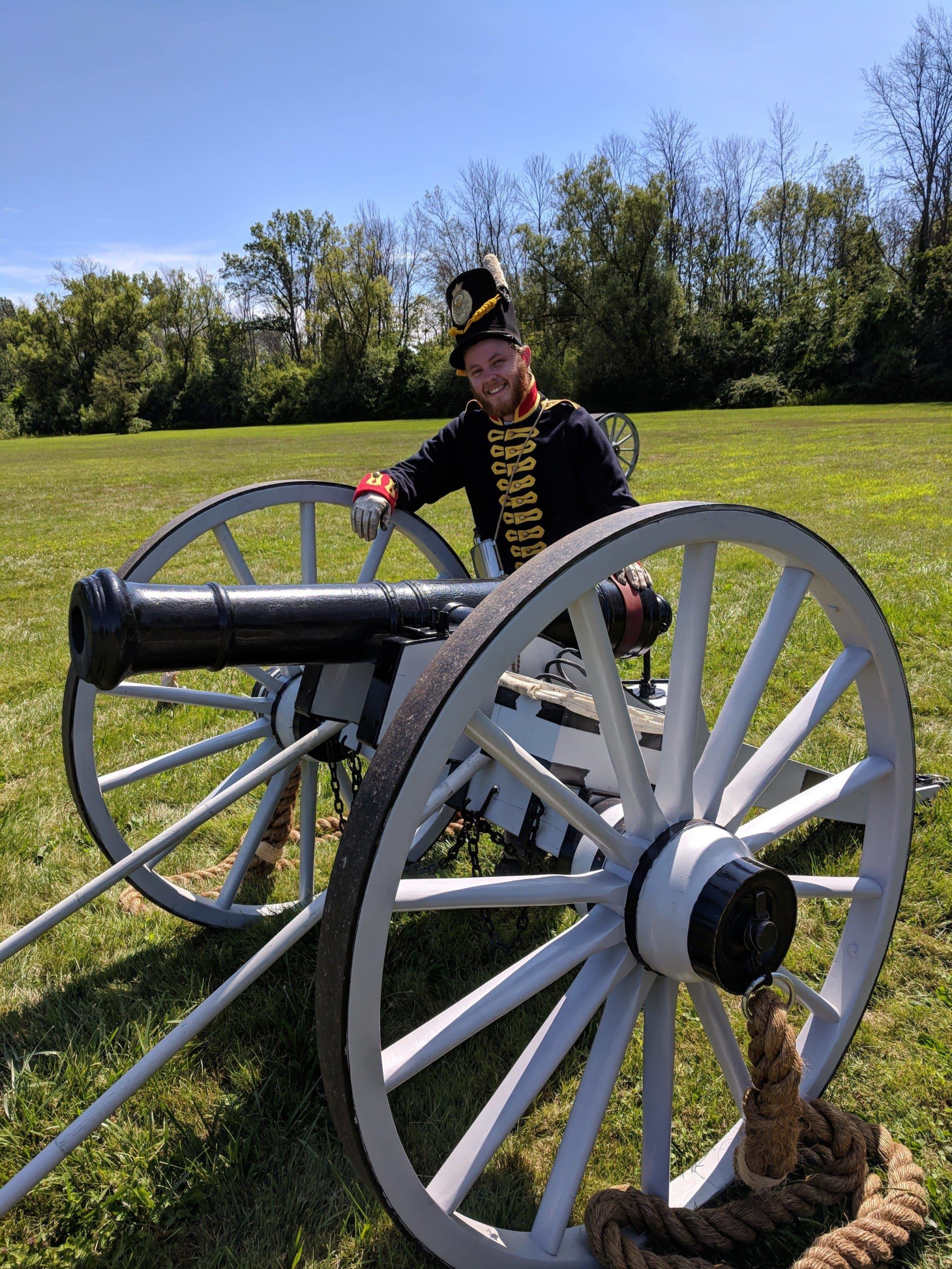 CURL Fellow Patrick Kinghan stands behind a cannon, wearing civil war re-enactment attire.