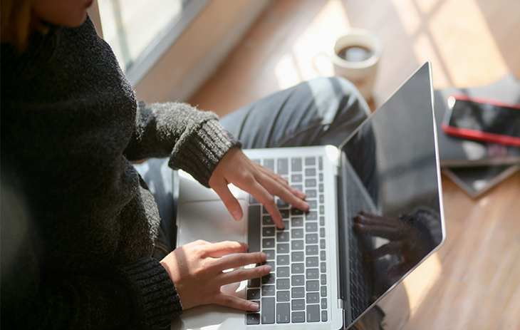 An overhead picture of a person browsing the internet on their laptop.