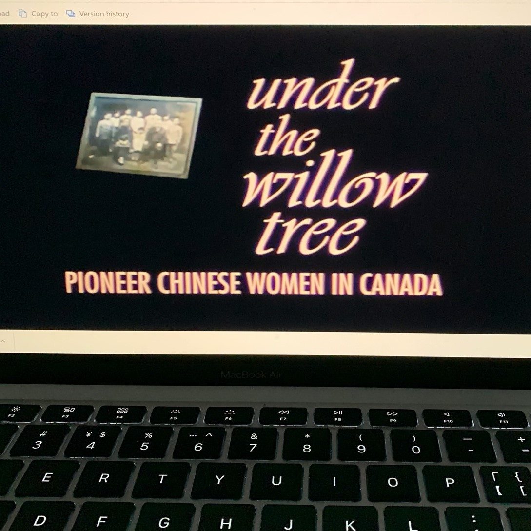 On a black laptop, a screenshot of the title sequence of the film, "Under the Willow Tree: Pioneer Chinese Women in Canada" is shown. 