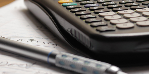 Spirit of Math Banner Pen and calculator sitting on a sheet of paper