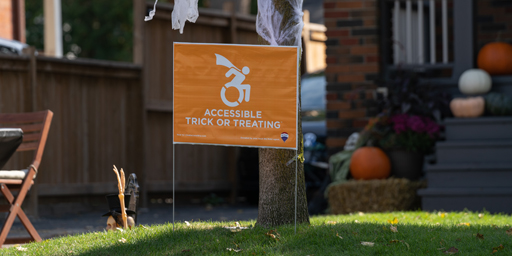 Treat Banner Treat Accessibly sign on a lawn during Halloween