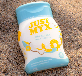 Image of a justmyx bottle on sand